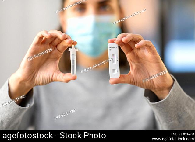 close up of woman holding self coronavirus test