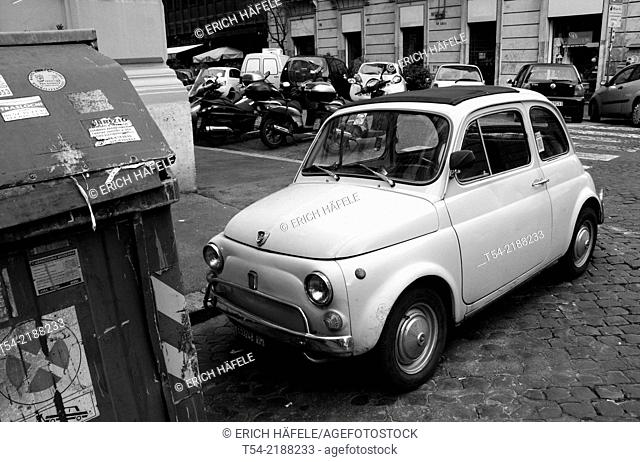 An old Fiat 500 is standing on a small parking Place in Rome