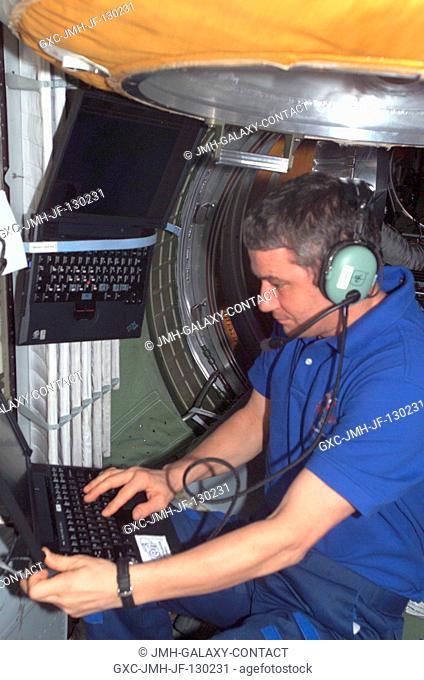Cosmonaut Valery G. Korzun, Expedition Five mission commander, uses an amateur radio in the functional cargo block (FGB) on the International Space Station...