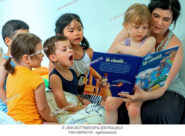 Pre-school teacher Catherina Meyer reads a story to the children Lea Sophie (L-R), Vu Minh Phuc, Philip, Le Yen Nhi and Angelina prior to their napping time at...