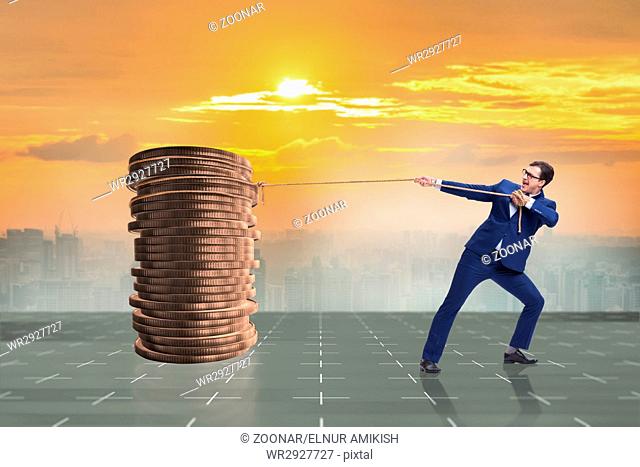 Businessman pulling stack of gold coins