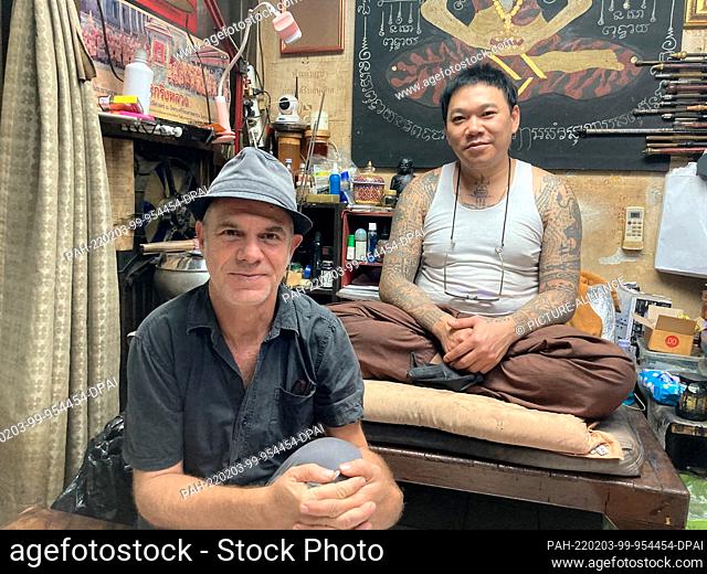 PRODUCTION - 17 January 2022, Thailand, Bangkok: Sak Yant tattoo master Ajarn Neng (back) and German author Tom Vater, who has written a book on the sacred...