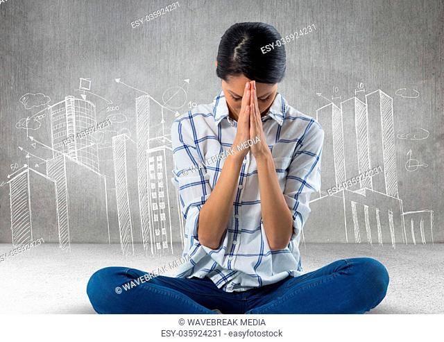 Woman praying meditating in front of city drawings