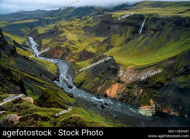 Iceland landscape of highland valley and river Fossa with blue water stream and green hills and moss covered cliffs. South Iceland