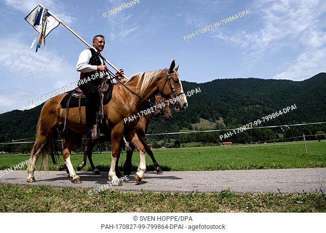 Participants of the traditional 'Rosstag' (horse day) pass by meadows and mountains at the Tegernsee lake in Rottach-Egern, Germany, 27 August 2017