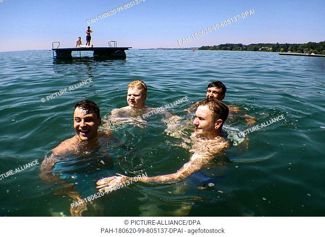 20 June 2018, Germany, Friedrichshafen: Four men take a swim in Lake Constance. Photo: Felix Kästle/dpa. - Friedrichshafen/Baden-Wuerttemberg/Germany
