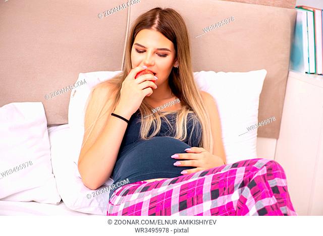 Happy young pregnant woman in the bed