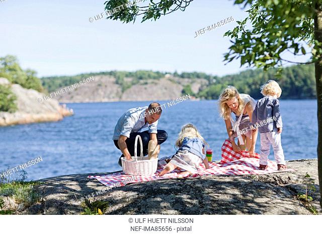 Family preparing for picnic beside lake