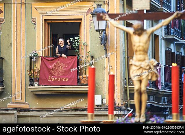 05 April 2023, Spain, Granada: A woman raises her arm and with powerful gestures sings a ""saeta"" from a balcony to the Cristo del Consuelo (Christ of...