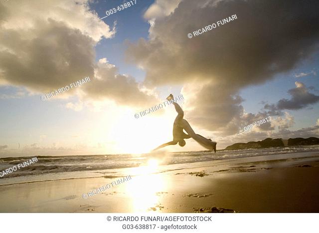 Capoeira player training and exercising in the beach, Brazil