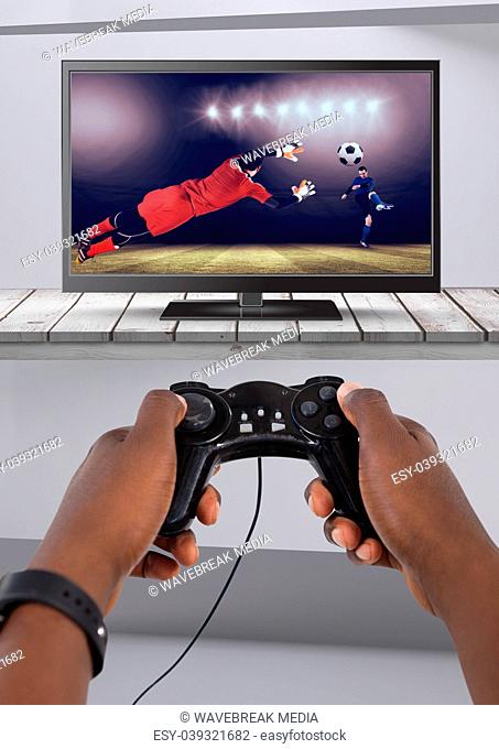 Playing soccer computer game with controller in hands