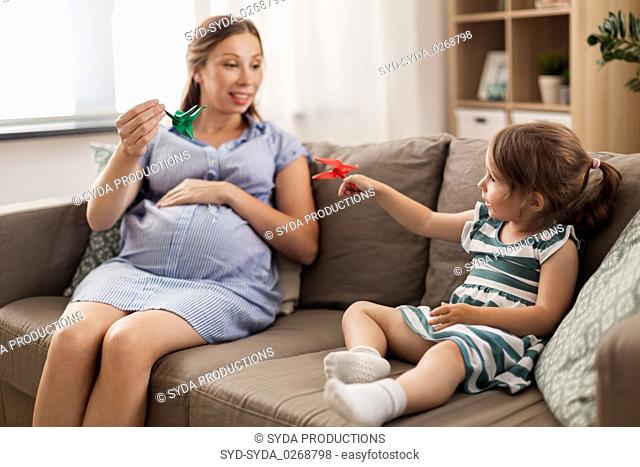 pregnant mother and daughter with crane origami