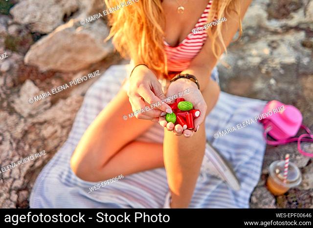 Young woman sitting on rocky beach