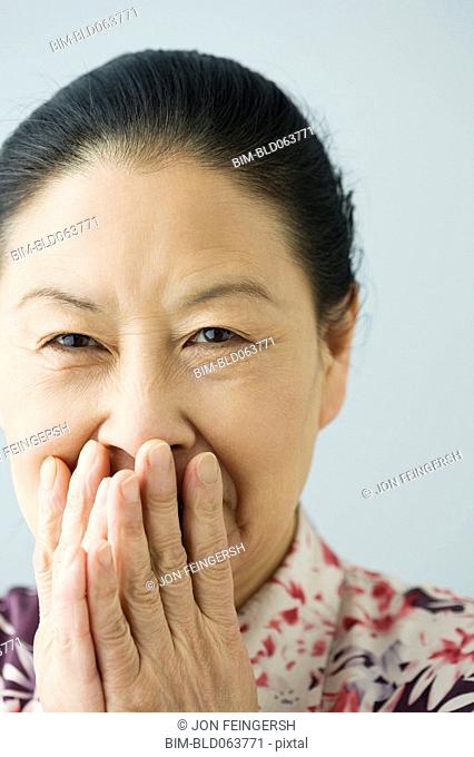 Asian woman covering her mouth