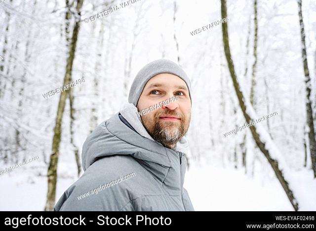 Smiling man wearing warm clothing at winter park
