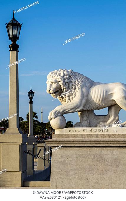 A lion statue from St. Augustine's Bridge of Lions in Florida. The Cross of Mission Nombre de Dios in the background