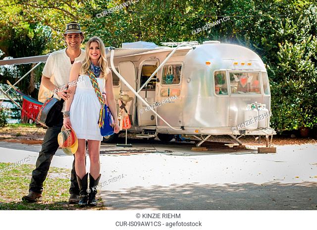 Portrait of couple in front of their converted boutique airstream trailer