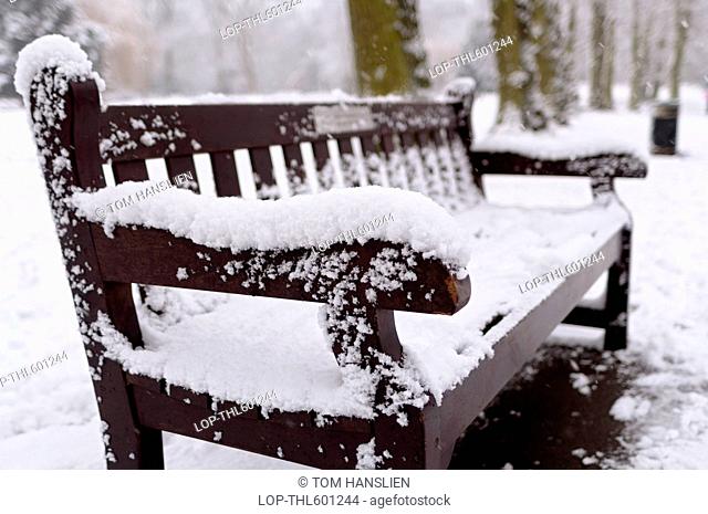 A snow-covered bench in Waterlow Park in North London