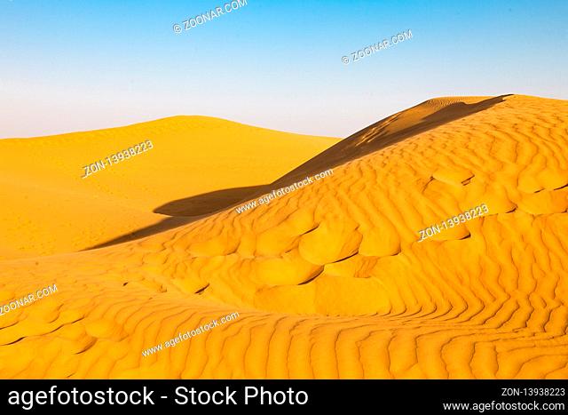 Beautiful yellow sand dunes. The desert of India. Desert at sunset Golden waves of sand in the desert