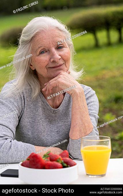 Smiling senior woman sitting in garden