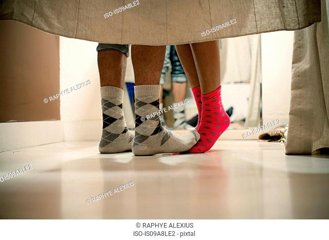 Young couple wearing socks in changing room, low section