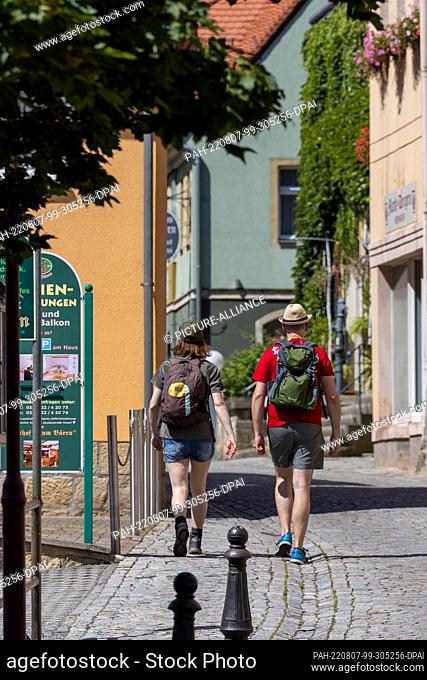 07 August 2022, Saxony, Bad Schandau: Tourists walk through an empty street. The situation in the forest fire area of the Saxon Switzerland National Park is not...