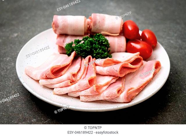 sliced raw pork bacon on plate