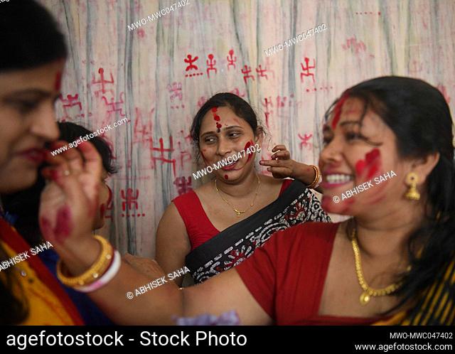 Female devotees share Sindur, red holy powder with each other at the Lakshmi narayan temple for the good of the family on the occasion of Pohela Boishakh