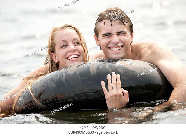 Young couple floating in inflatable ring