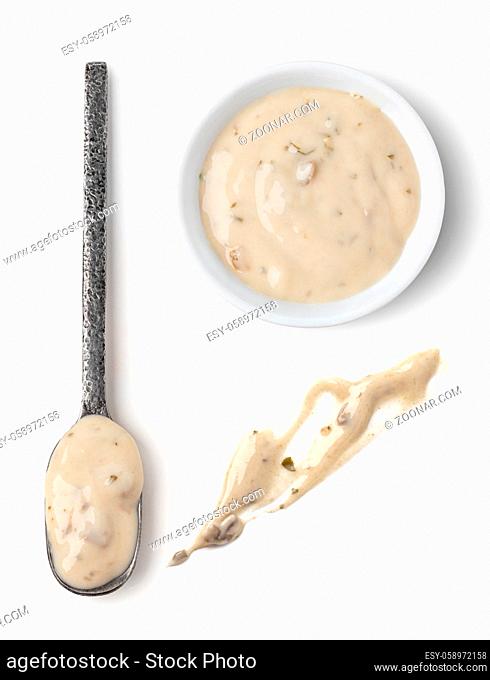 Bowl and spoon with mushrooms sauce isolated on white background