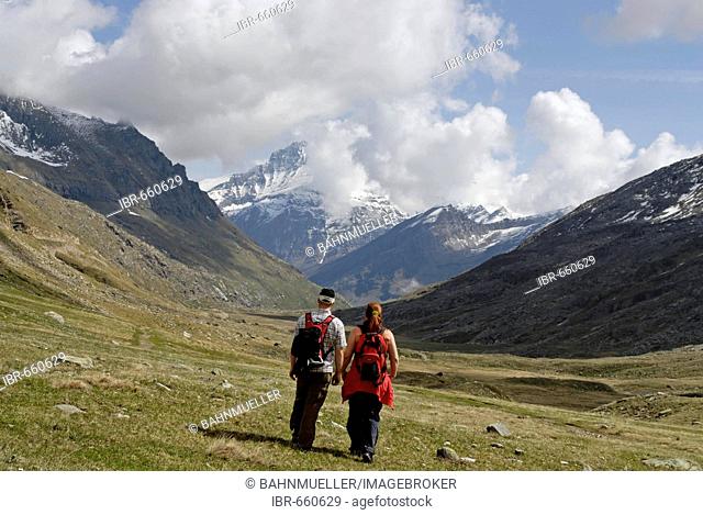 Gran Paradiso National Park between Piemonte Piedmont and Aosta valley Italy Garian Alps hikers at the old path to the Val Salvarenche at the high plateau Plan...