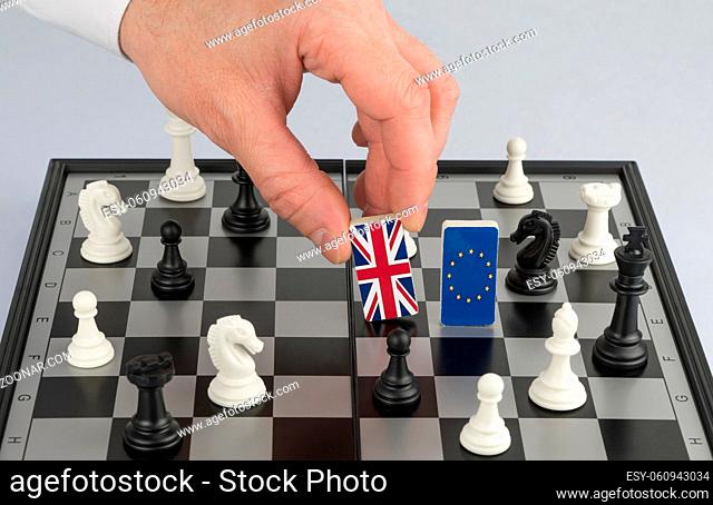Hand policy raises the figure with the flag of Britain. The concept of political game and chess strategy Brexit