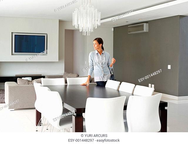 Pretty woman standing in modern dining room looking outward