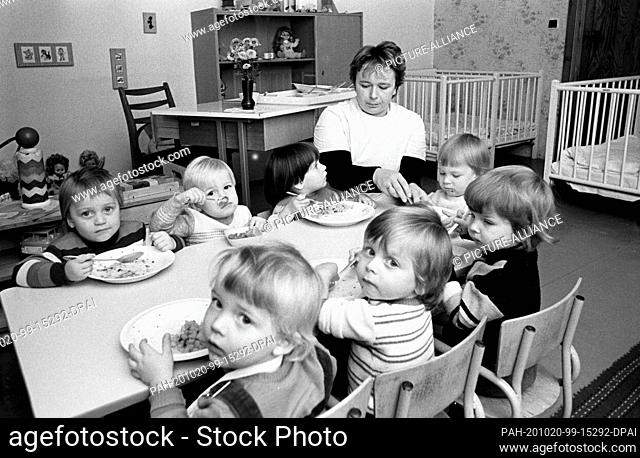 15 November 1984, Saxony, Wildenhain: In November 1984, children sit at the table with their teacher at a village kindergarten in Wildenhain (near Eilenburg)...