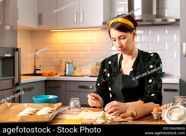 Women preparing homemade food pie, pizza in a cozzy kitchen. Hobbies and family life concept