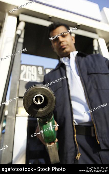 Young man pumping gas