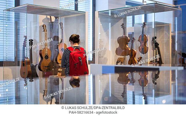 A woman looks at the exhibition 'Pomposa - Violins for Bach. The Hoffmann Workshop in Leipzig' in the Grassi Museum in Leipzig,  Germany, 06 May 2015