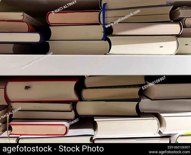 Books placed one on top of the other on a shelf