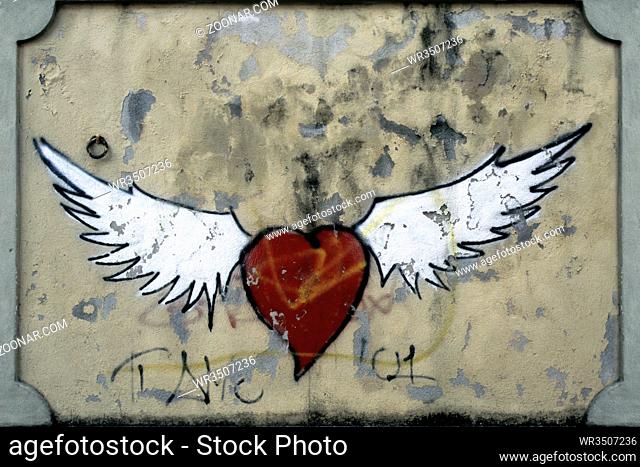Graffito zeigt ein stilisiertes rotes Herz mit zwei weissen Fluegeln. Querformat. Graffito shows a stylized red heart with two white wings