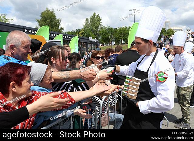 RUSSIA, NOVOSIBIRSK - JUNE 25, 2023: Giving out rissoles cooked at the Siberian Kitchen food festival held as part of celebrations of the 130th anniversary of...