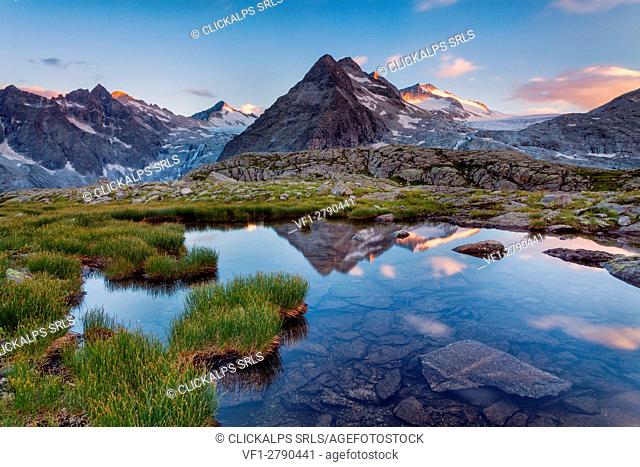 Genova valley, Adamello-Brenta natural park, Trentino Alto Adige, Italy. The Three Lobbie and Adamello glacier are reflected at sunset into a small lake near...