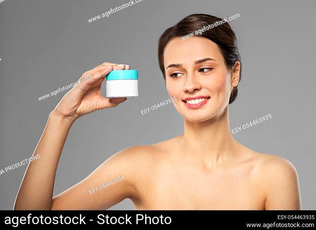happy young woman holding jar of cream