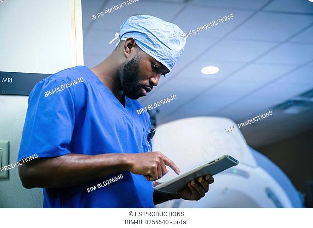 Serious black nurse using digital tablet