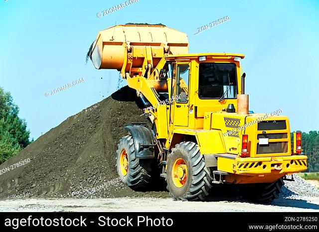heavy construction loader bulldozer moving breakstone at construction area