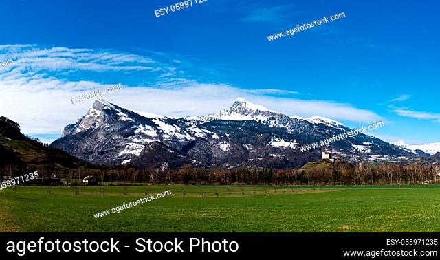 panorama mountain landscape in the Rhine Valley of Switzerland near Sargans with the castle in Balzers in the foreground in late winter