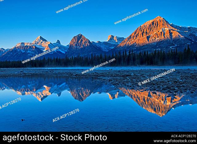 Sunrise on the Canadian Rocky Mountains reflected in the Athabasca River. Icefields Parkway. Jasper National Park Alberta Canada