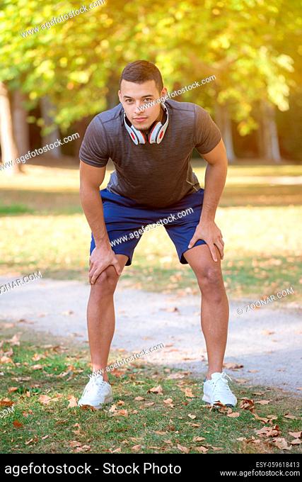 Young latin man runner running sports training fitness ready start portrait format outdoor