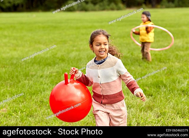 happy little girl playing with hopper ball at park