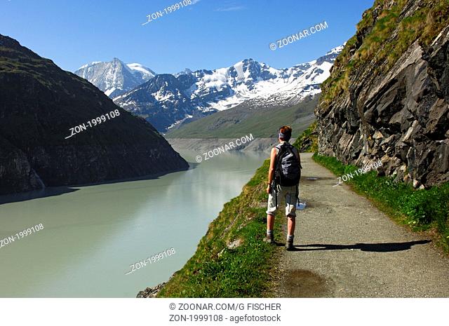 Wanderer am Stausee Lac des Dix mit Mont Blanc de Cheilon hinten, Val d'Herens, Wallis, Schweiz / Hiker at the storage lake Lac des Dix with Mt