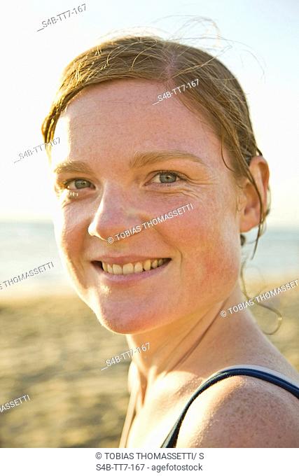 Smiling young woman on beach, Melbourne, Victoria, Australia
